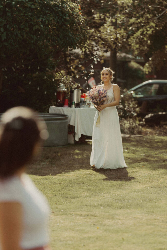Bride walking down the aisle during backyard wedding ceremony