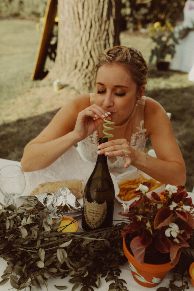Bride drinking alcohol from curly straw