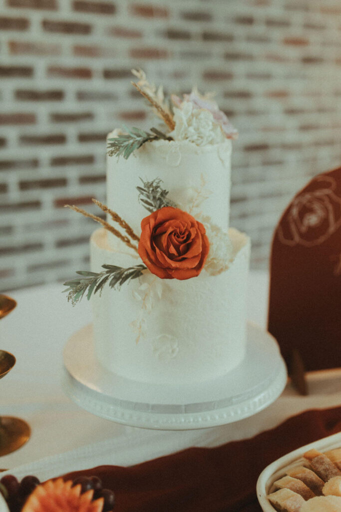 white wedding cake with orange and white florals