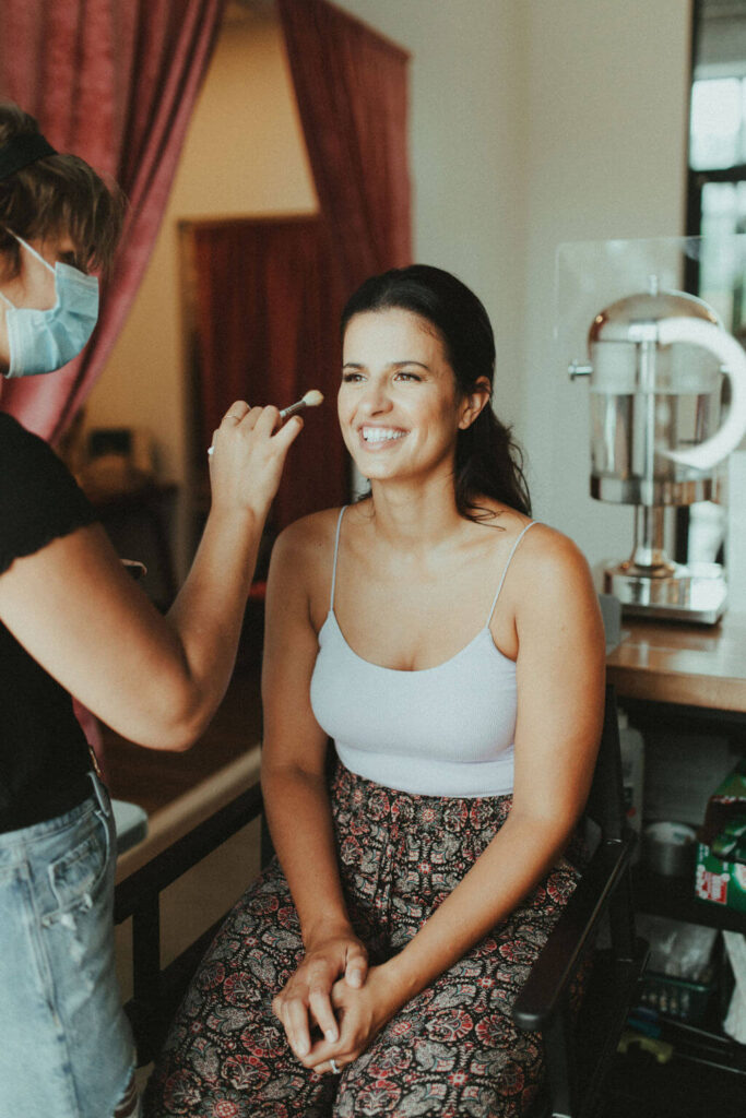 Bride getting makeup done for boho chic elopement