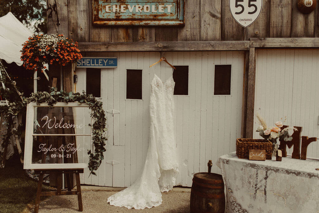 White wedding dress hanging from barn rafters 