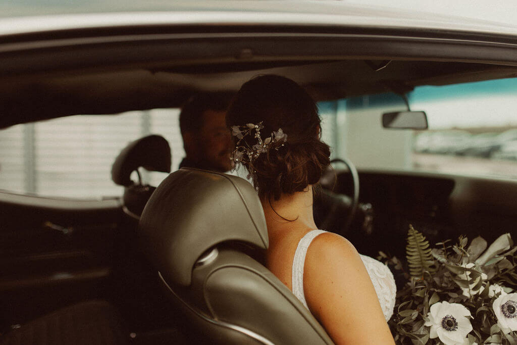 Bride and groom portraits in classic car
