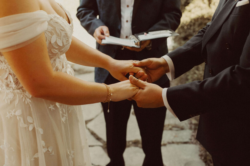 Bride and groom hold hands during Elora Ontario wedding ceremony