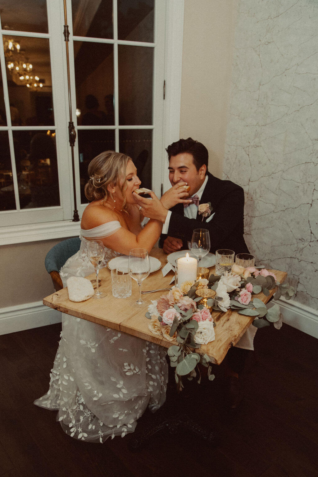 Bride and groom feed each other cake at The Wild Tart wedding reception