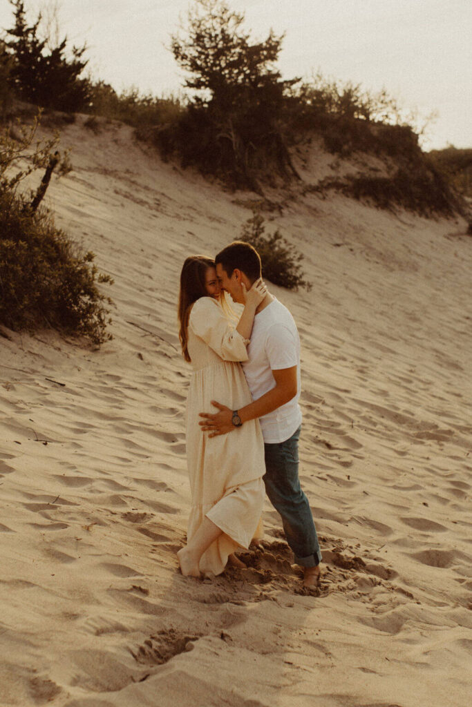Man and woman hugging at Ontario sand dune engagement session